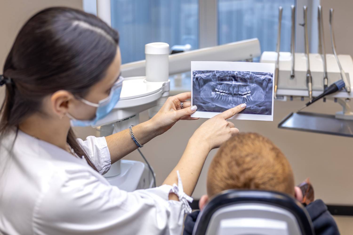 Young female dentist showing a patient a dental X-ray during a consultation