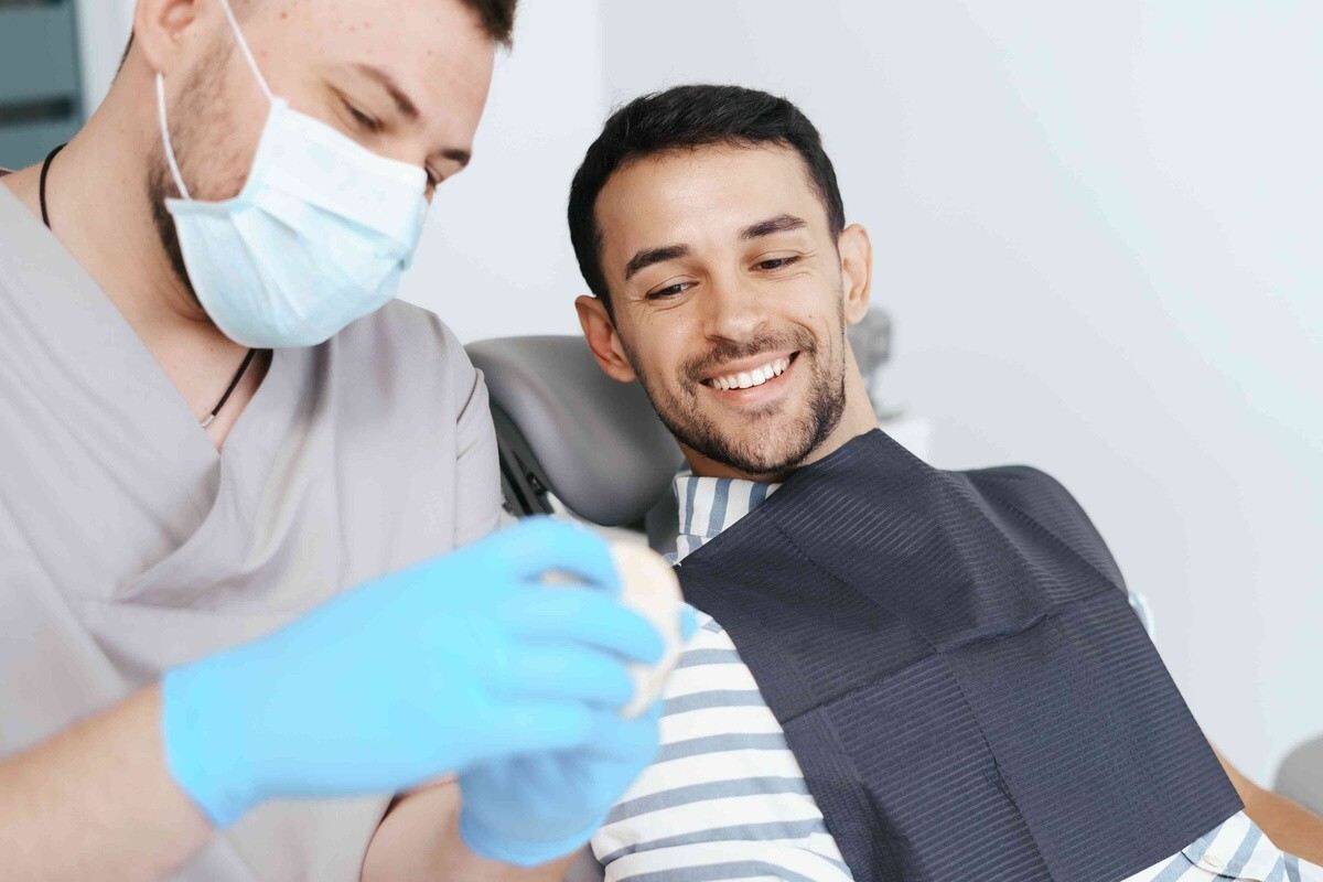 Dentist treating a smiling patient during a dental crown consultation and treatment visit
